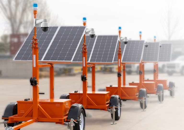 Five orange mobile surveillance trailers positioned in a row in a parking lot