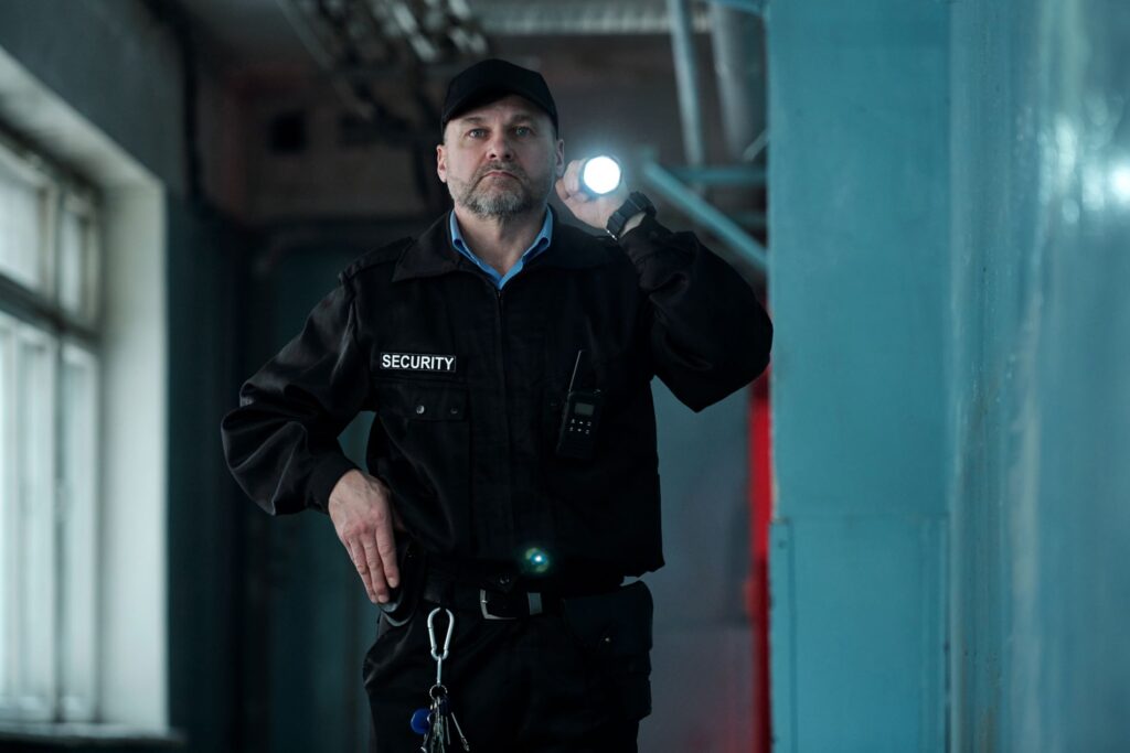 security guard with flashlight inspecting hallway