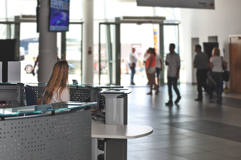 Security guard sitting at security desk in busy building