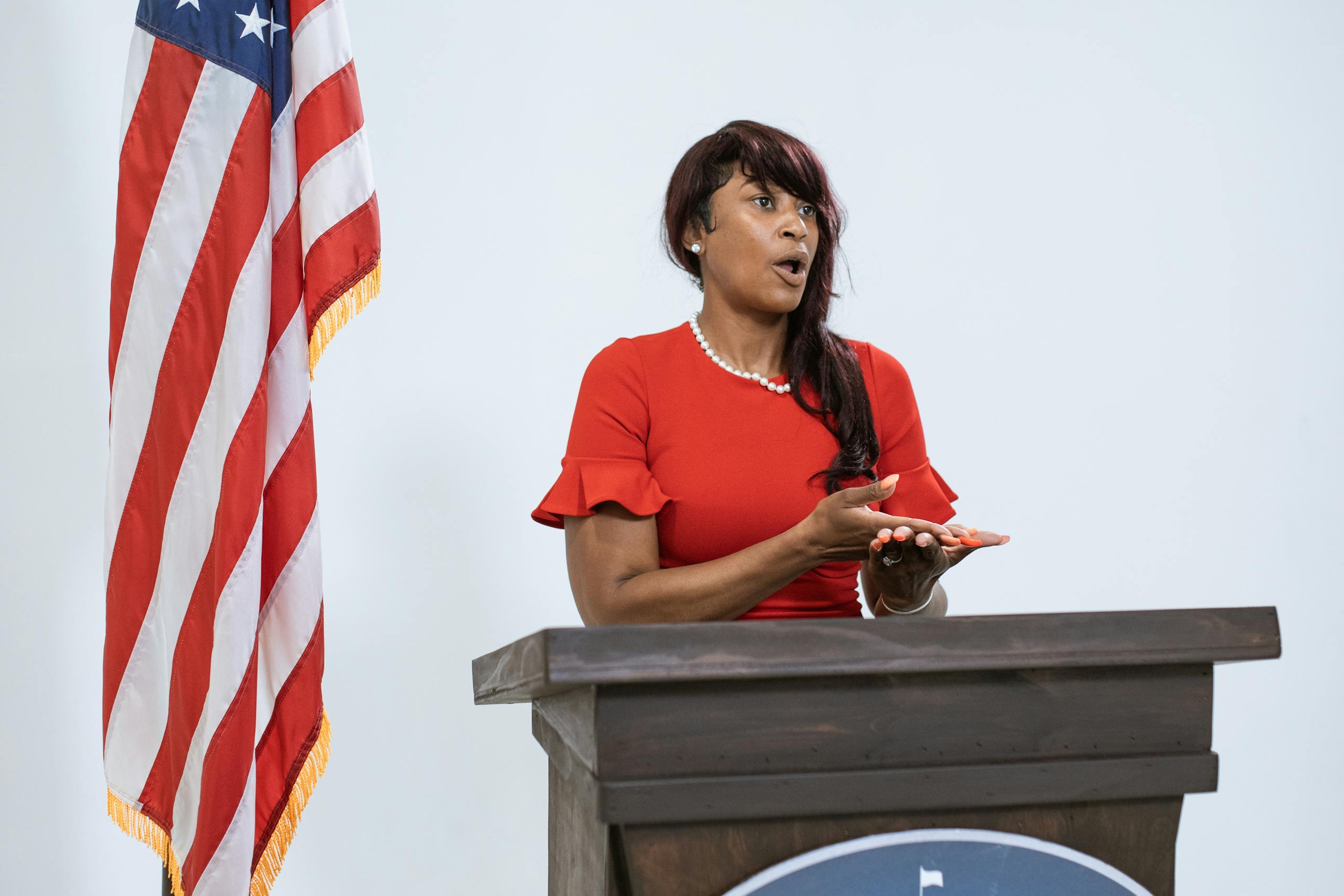 Woman in Red Dress Behind a Podium